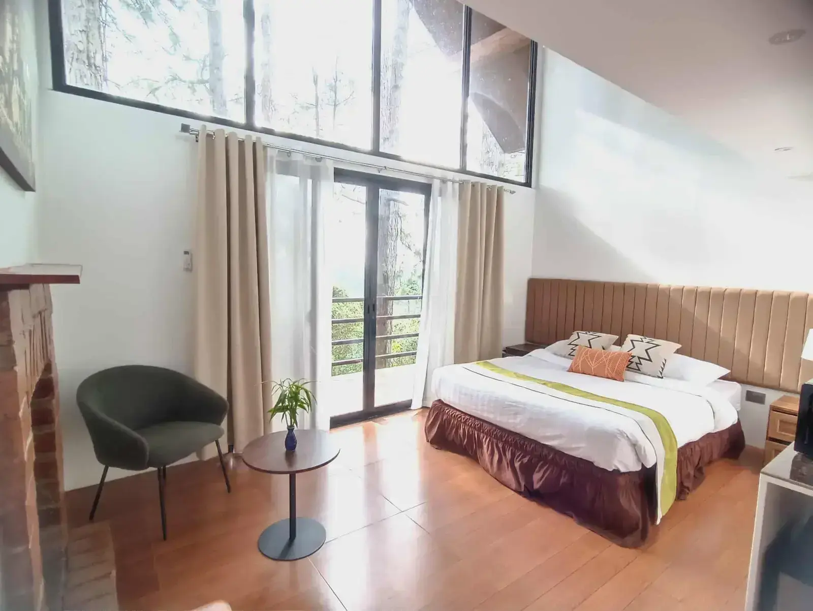 King Fisher Cabin with a queen bed and tall windows looking out to greenery
