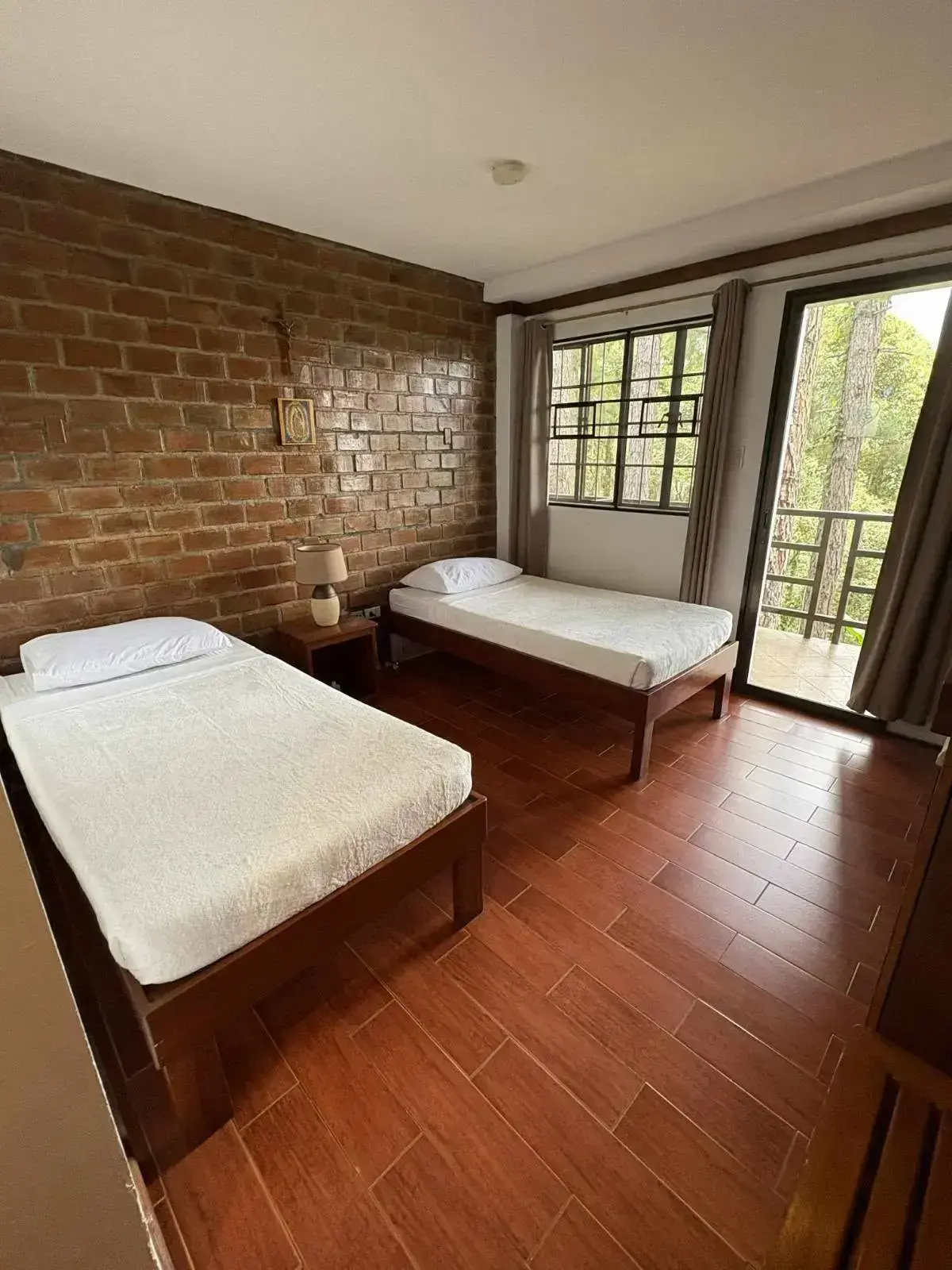Standard Room with twin beds, warm wooden flooring and a veranda